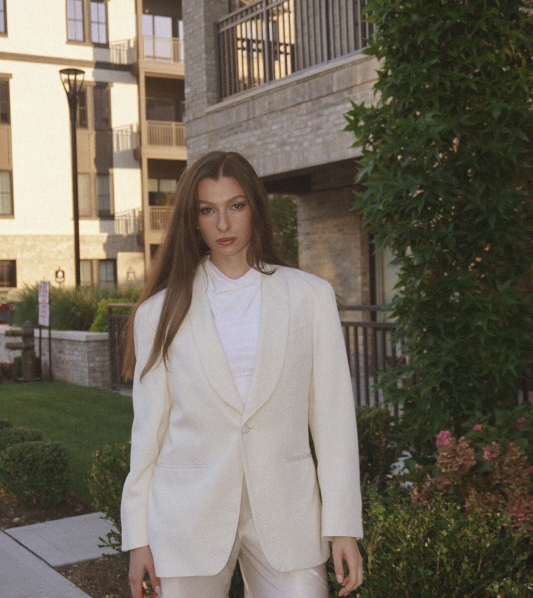 Adele in a cream blazer and ivory trousers in late afternoon light