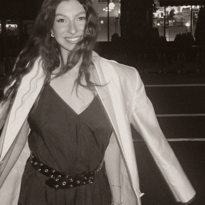 A slip dress under a cream coat at night