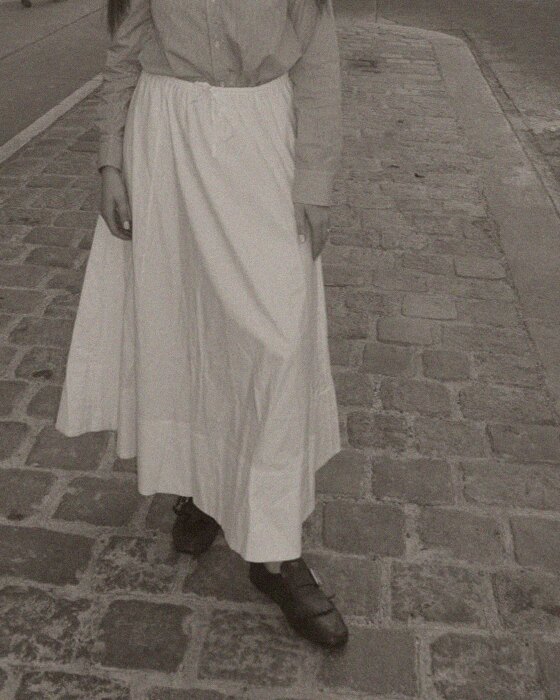 A long white cotton skirt over brown shoes